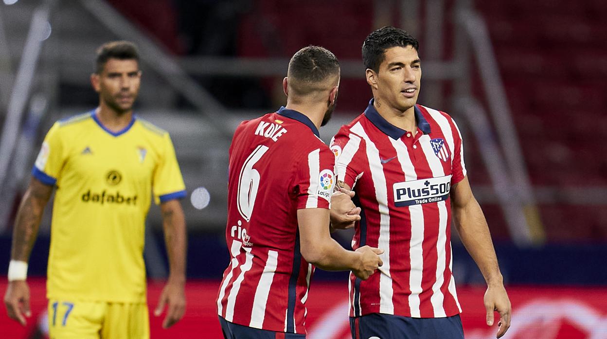 Augusto, difuminado, observa como Luis Suárez y Koke se felicitan tras un gol.