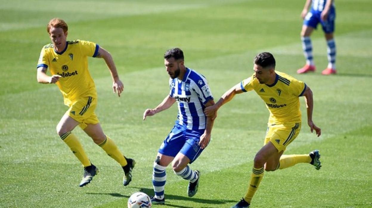 Alcalá intenta frenar a un rival ante la mirada de Álex, autor del gol el año pasado en Vitoria.