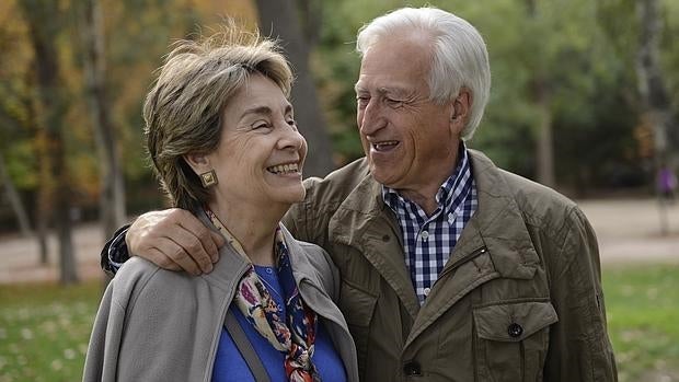 Una pareja de ancianos camina por el Retiro