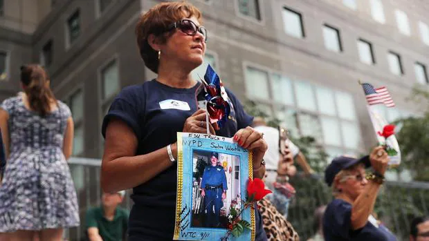 Una mujer sostiene la imagen de un policía fallecido en los atentados del 11-S en Nueva York durante una marcha en recuerdo de las víctimas
