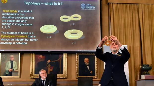 Thomas Hans Hansson, uno de los miembros de la Real Academia de Ciencias, explica el premio con una especie de bagel en las manos