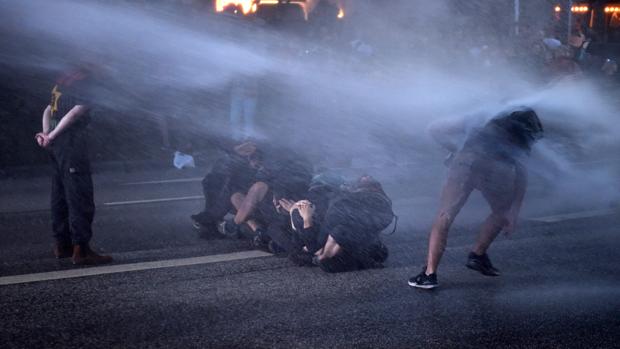 La policía dispara cañones de agua contra los manifestantes durante una protesta contra la celebración de la cumbre del G20 en Hamburgo