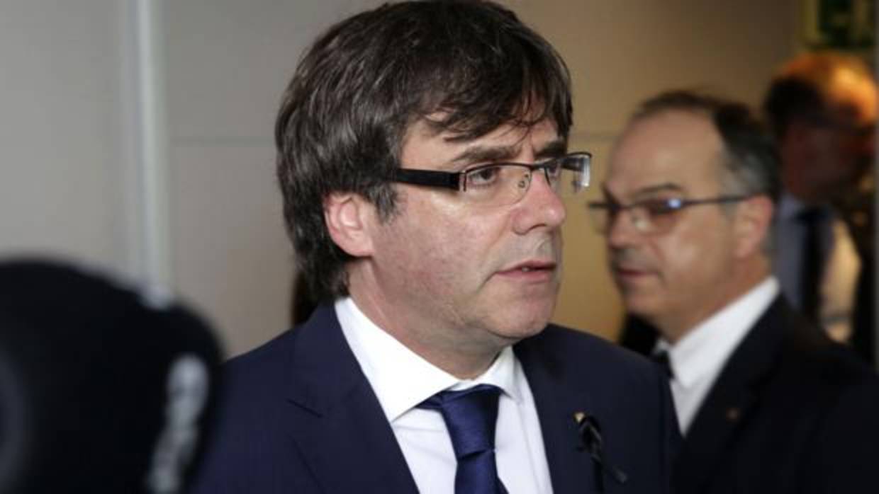 El presidente de la Generalitat, Carles Puigdemont, junto al conseller de Presidencia, Jordi Turull (atrás)