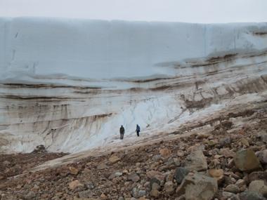 Investigadores caminan junto a una gruesa capa de hielo