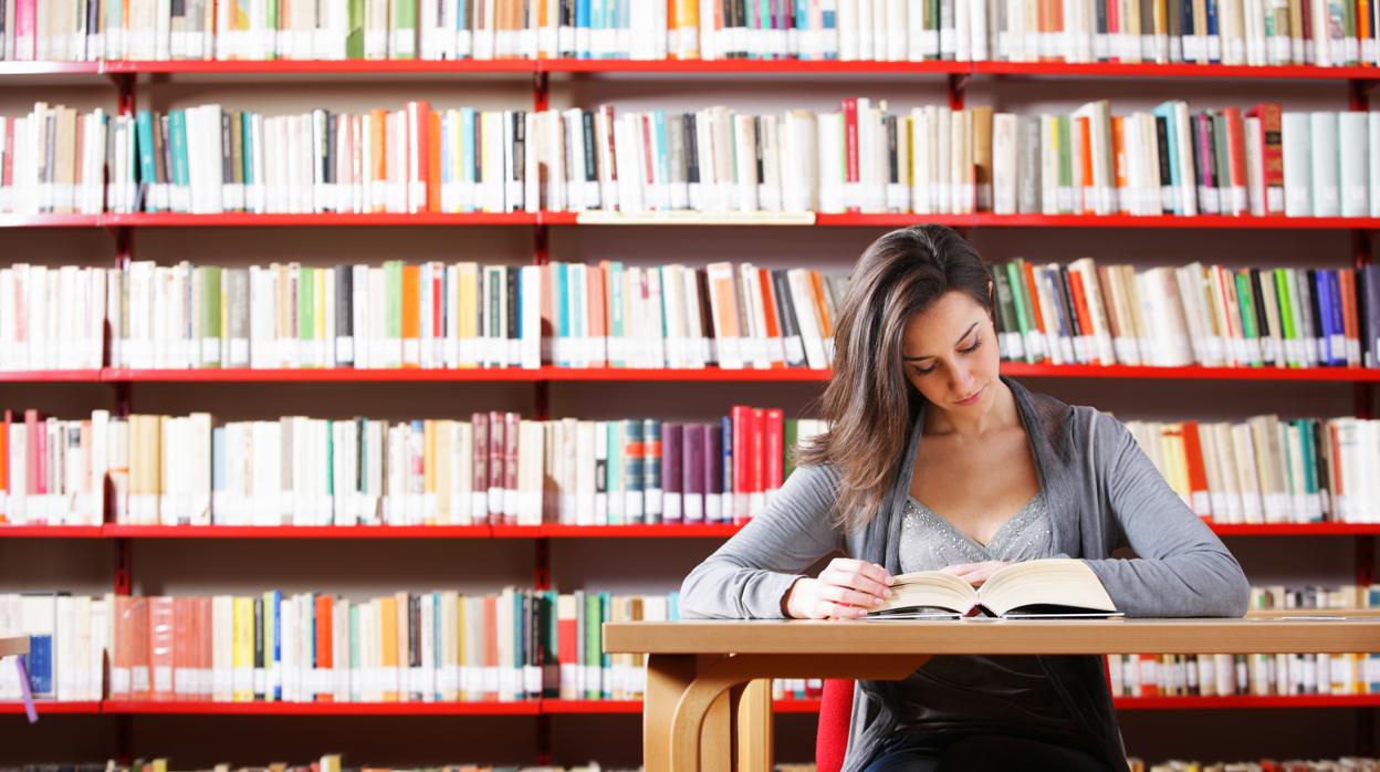 Una joven estudia en una biblioteca