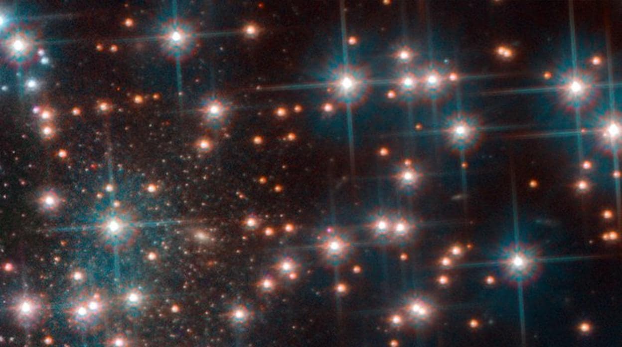 La imagen del Hubble muestra una parte del cúmulo globular NGC 6752. Detrás de las brillantes estrellas del cúmulo, se ve una colección más densa de estrellas débiles estrellas, una galaxia esferoidal enana desconocida hasta ahora