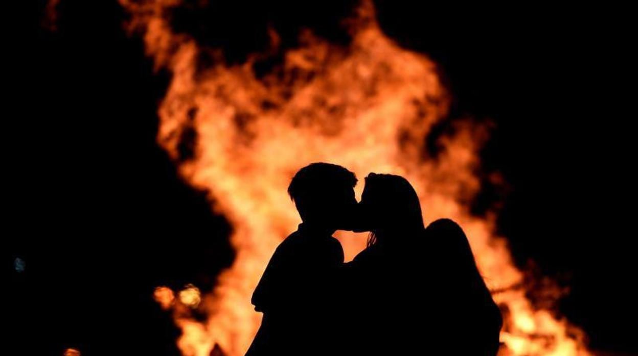 Una pareja se besa la noche de San Juan en la Playa de Poniente de Gijón