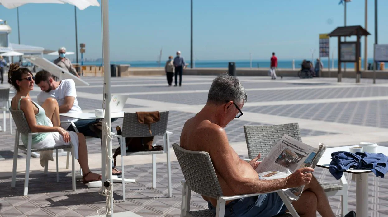 Varias personas disfrutan de una terraza en la playa de La Malvarrosa, en Valencia, este martes. El proceso de desescalada comenzó la semana pasada y podría extenderse hasta finales de junio