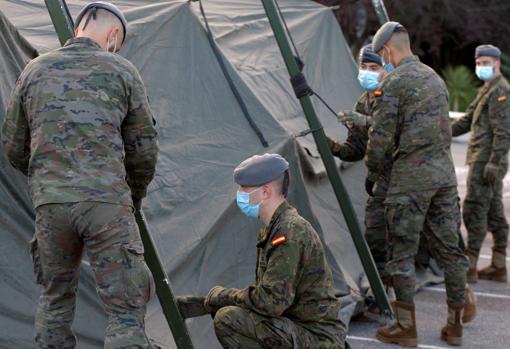 Soldados del Regimiento Príncipe de Asturias montan un hospital de campaña para el triaje de pacientes con COVID-19 en el aparcamiento del Hospital de Cabueñes, en Gijón, este viernes