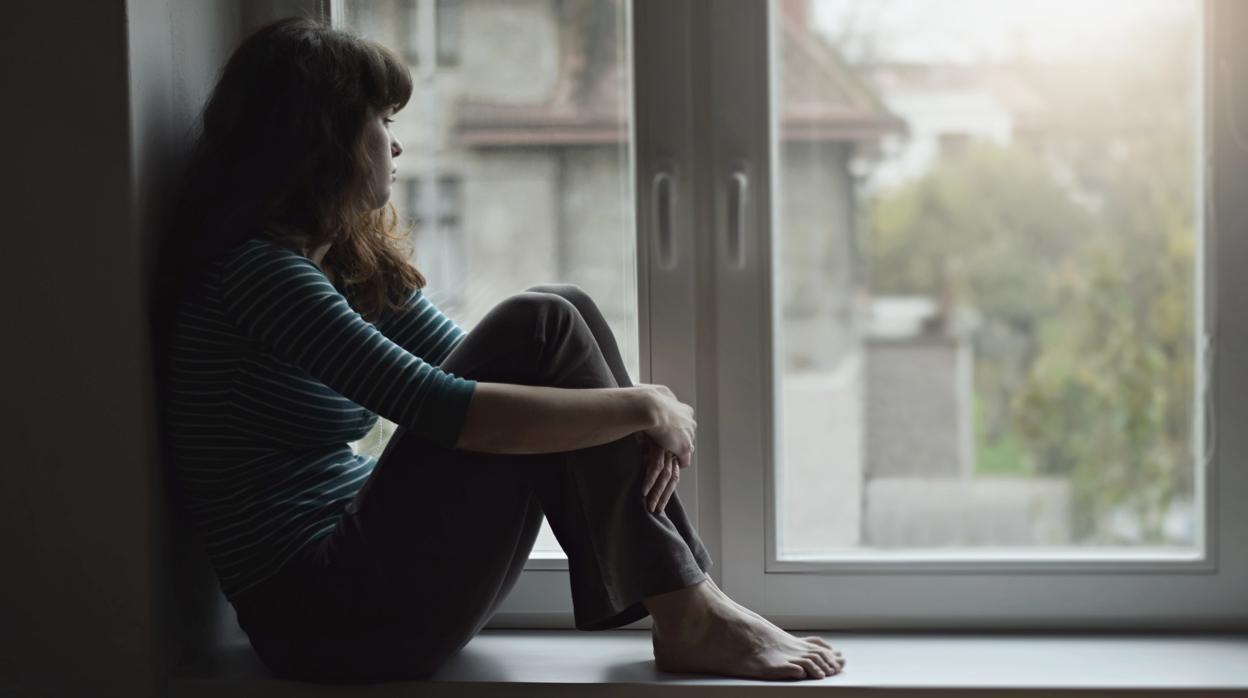 Una joven mira por la ventana