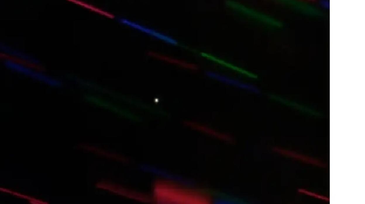 En la imagen, la miniluna 2020 CD3 aparece como un punto blanco en el centro. Las rayas de colores son estrellas