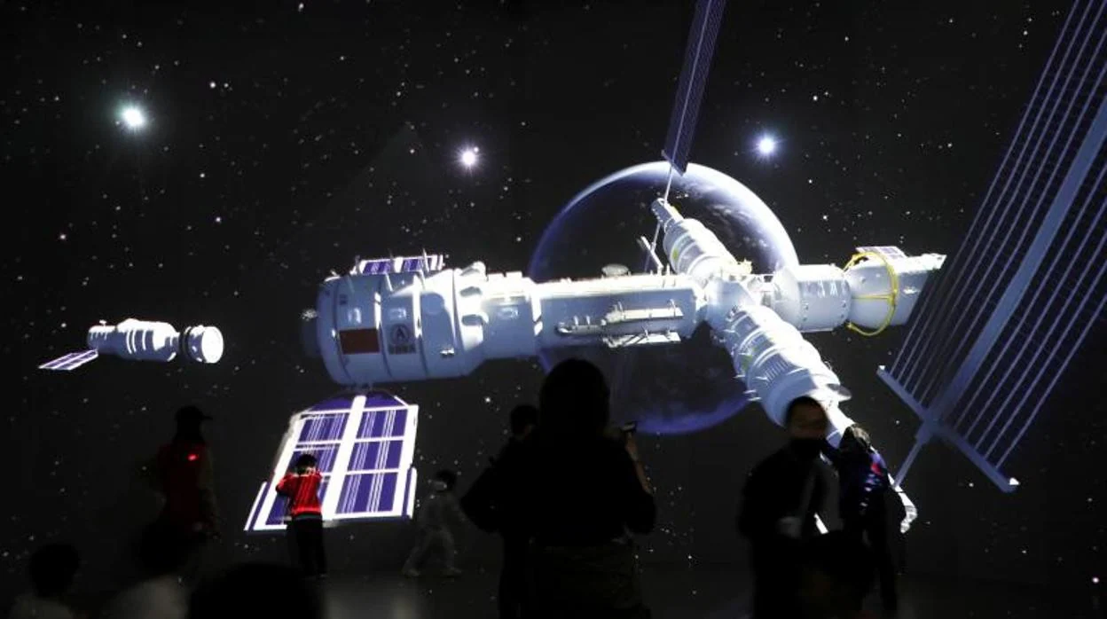 Visitantes del Museo de Ciencia y Tecnología de Pekín, frente a una pantalla con una imagen de la futura estación espacial china