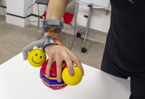 Uso del 'tercer pulgar' para completar una de las tareas de entrenamiento, sostener varias bolas con una mano