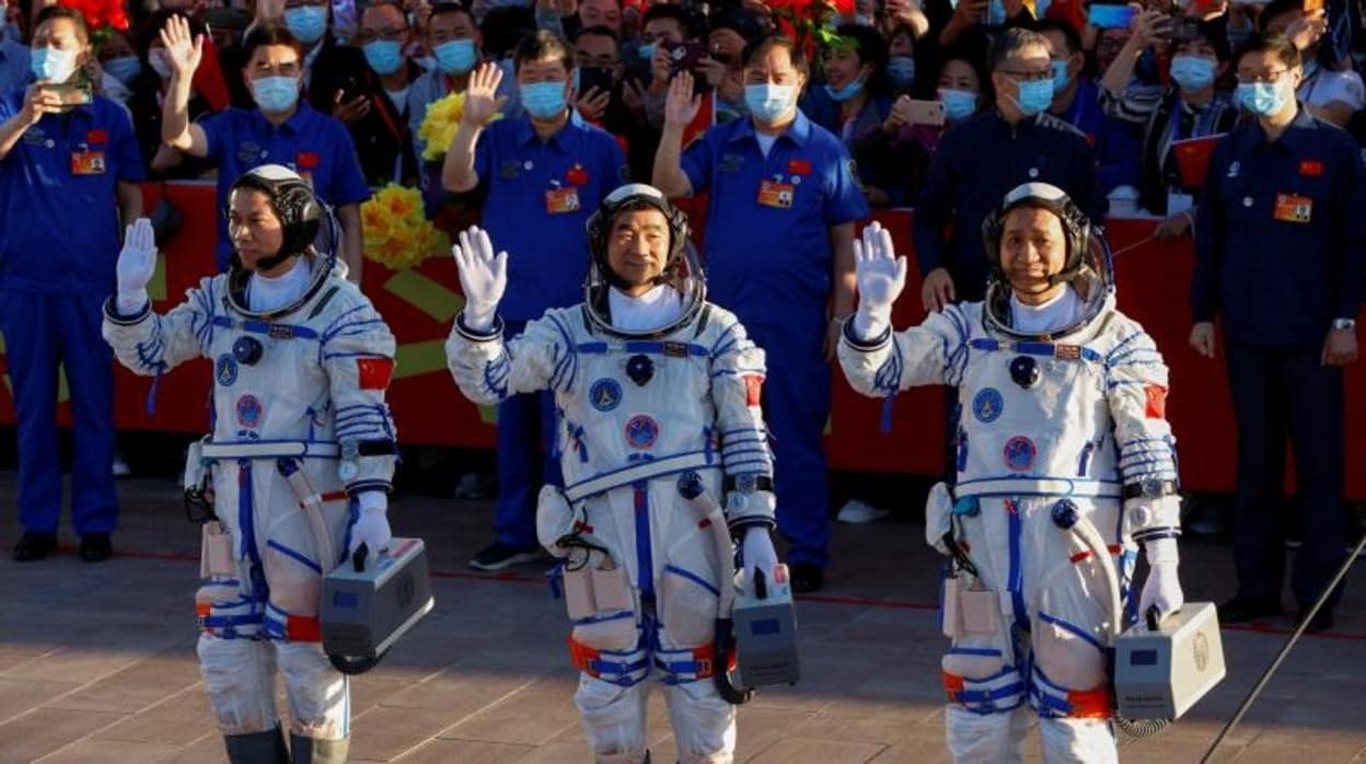 Los astronautas chinos Tang Hongbo, Nie Haisheng y Liu Boming saludan antes del lanzamiento