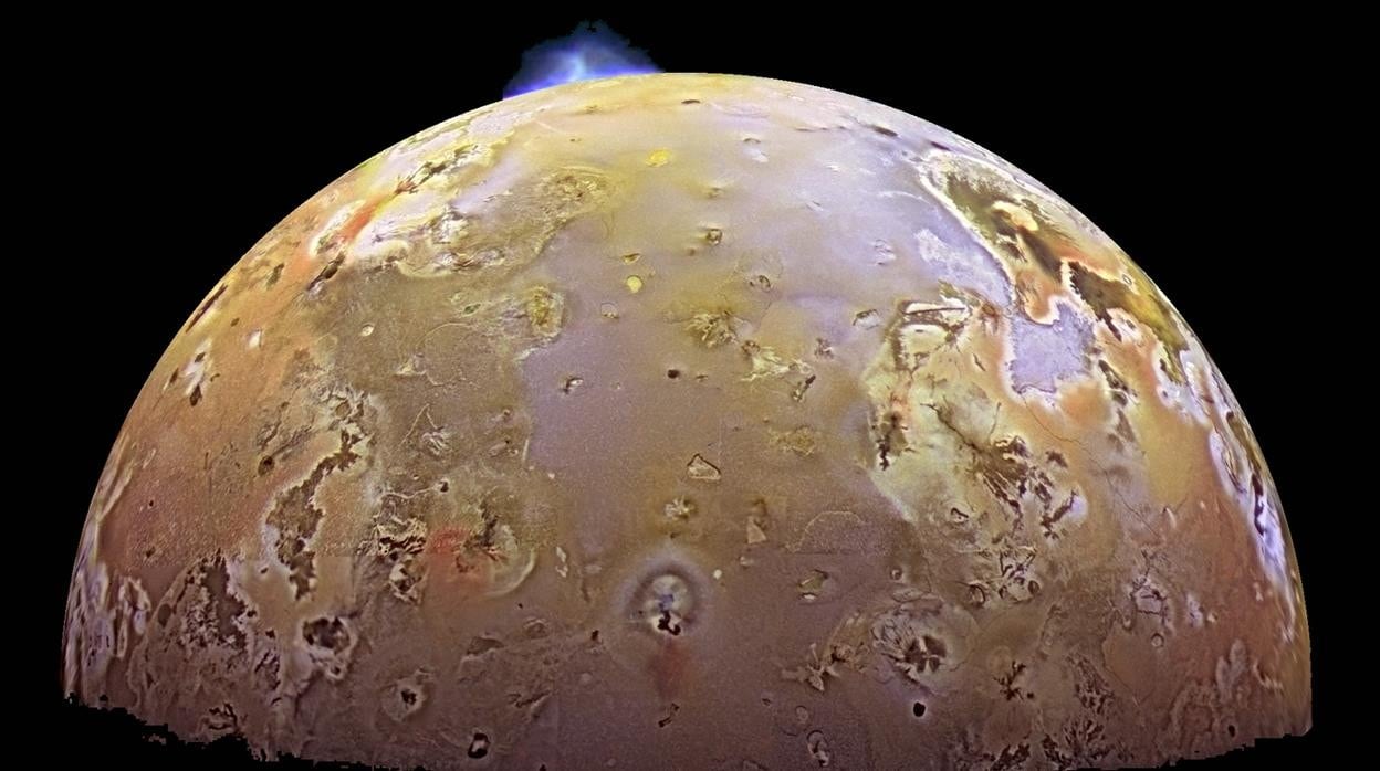 Una imagen de Io tomada por la sonda Galileo. En azul, una de las numerosas erupciones volcánicas que tienen lugar en el satélite de Júpiter