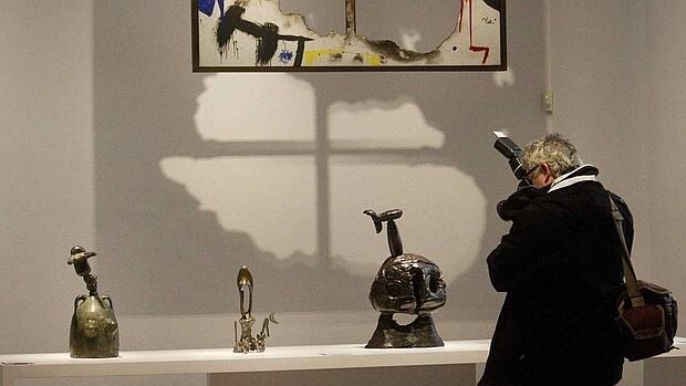 Una persona fotografía varias obras de Joan Miró
