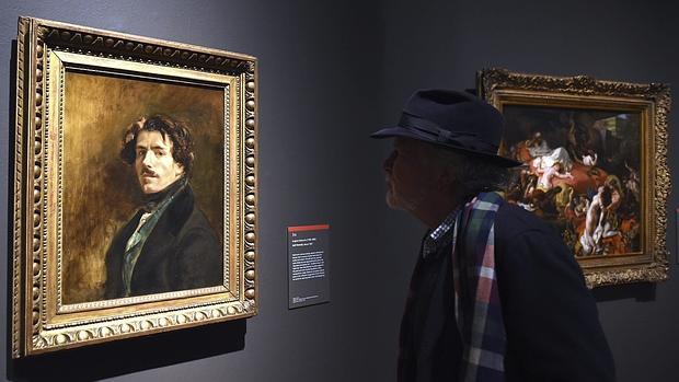 Un hombre admira el autorretrato de Delacroix, que cuelga en la exposición
