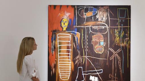 Una empleada de Sotheby's mira la obra «Air Power» de Basquiat