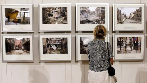 Una mujer contempla algunas exposiciones del Festival Internacional «Visa pour l'image»
