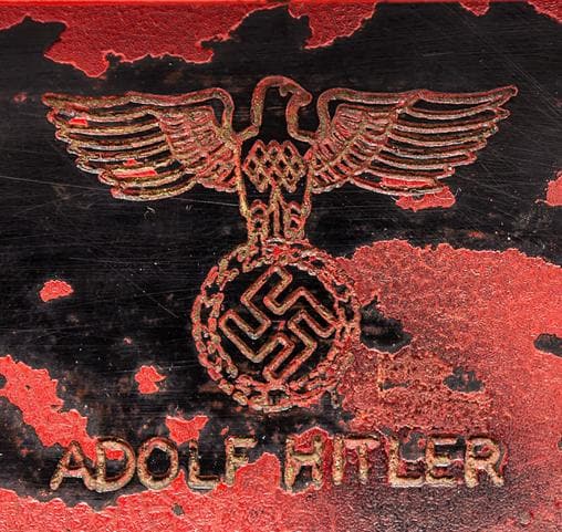 Reverso del teléfono de Hitler con su nombre y el símbolo del partido nazi