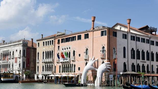 ¿Qué son esas manos que emergen del agua para sostener una fachada en Venecia?