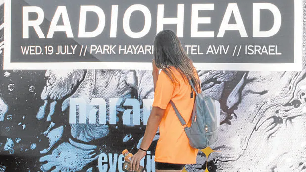 Un fan, frente al cartel del concierto de Radiohead en Israel