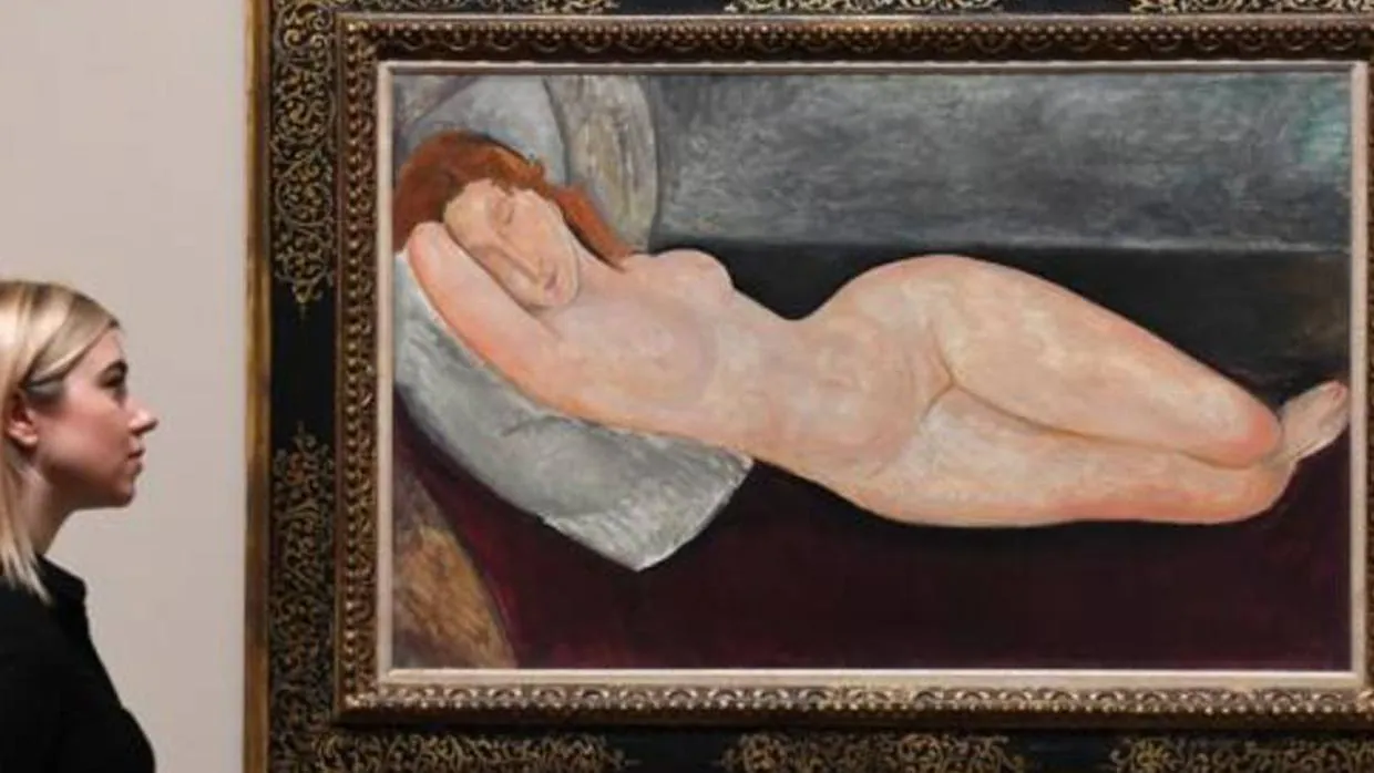 Una mujer posa junto a uno de los desnudos presentes en la exposición de Modigliani en la Tate Modern
