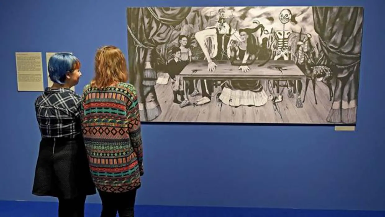 Dos visitantes contemplan «La mesa herida» de Frida Kahlo
