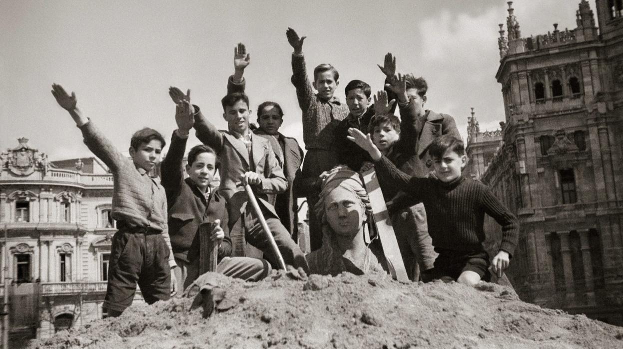 Niños saludando con el brazo en alto durante el desescombro de la Cibeles en 1939