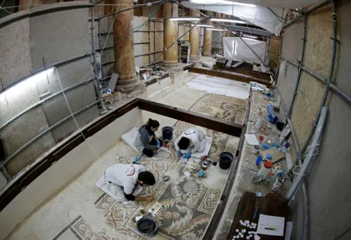 Los restauradores, trabajando en los mosaicos del suelo