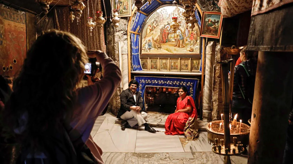 Una pareja se fotografía ante la Gruta de la Basílica de la Natividad, en Belén