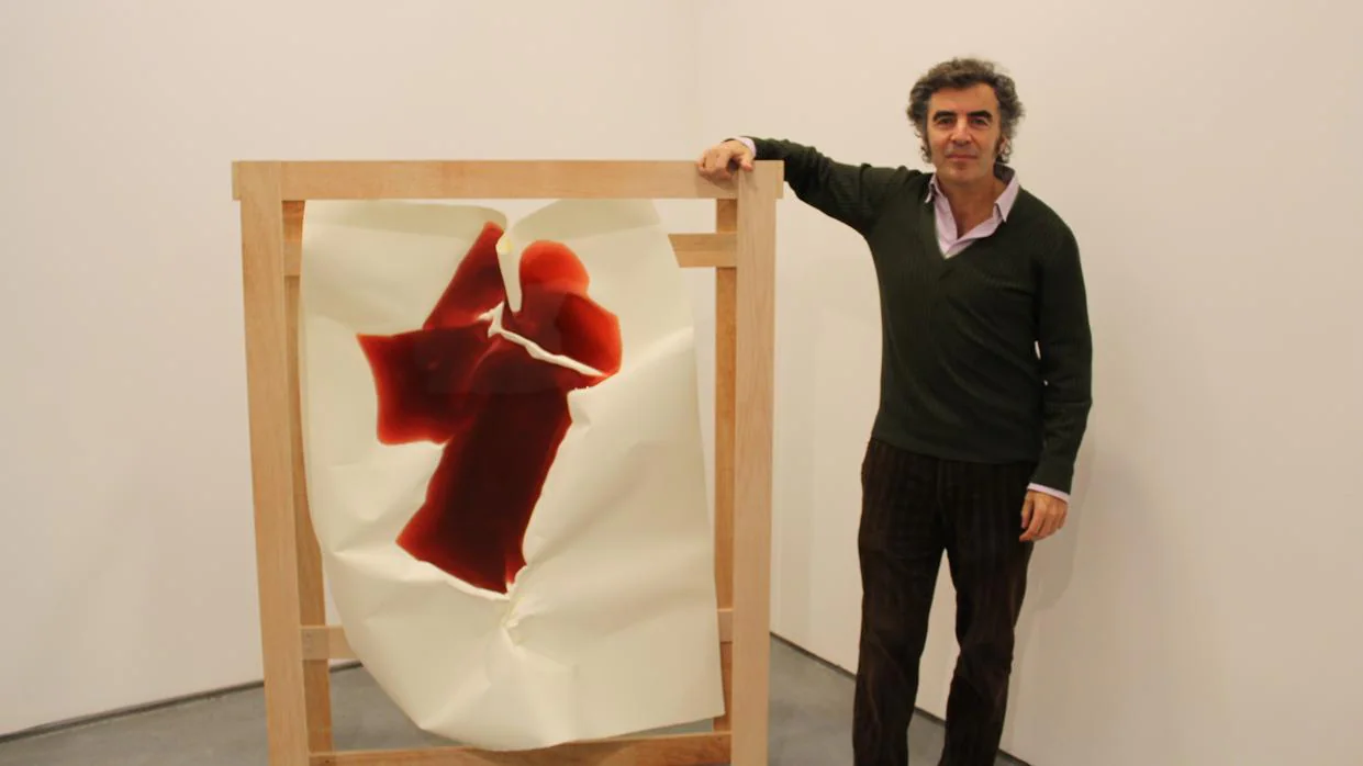 El galerista Alberto de Juan junto a una pieza de la serie «Lagos», del artista Miler Lagos