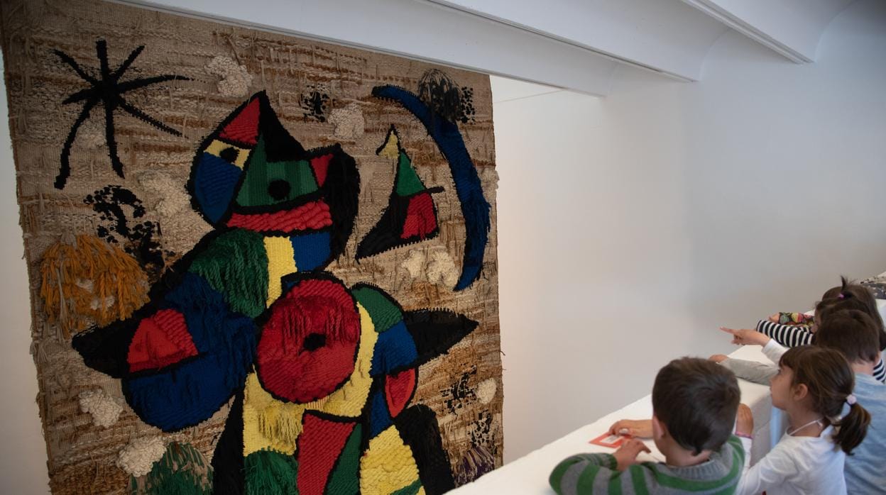 Un grupo de estudiantes observa el tapiz de Miró
