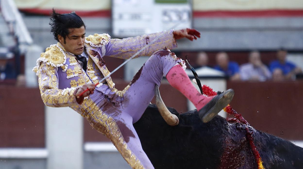 Diego San Román , en una fea voltereta, con el pitón a punto de hundirse en la piel