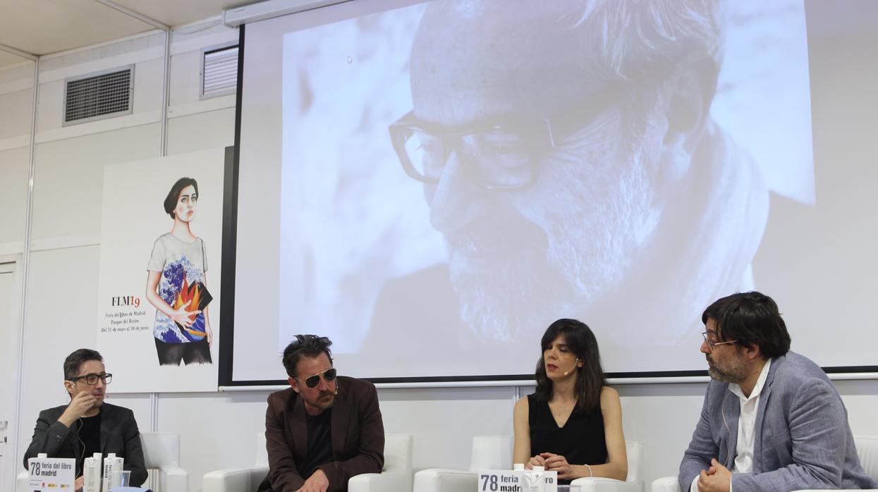 Los escritores Patricio Pron, Ray Loriga y Lara Moreno y el editor Miguel Aguilar, delante de una foto de Claudio López de Lamadrid durante el acto de homenja en la Feria del Libro de Madrid