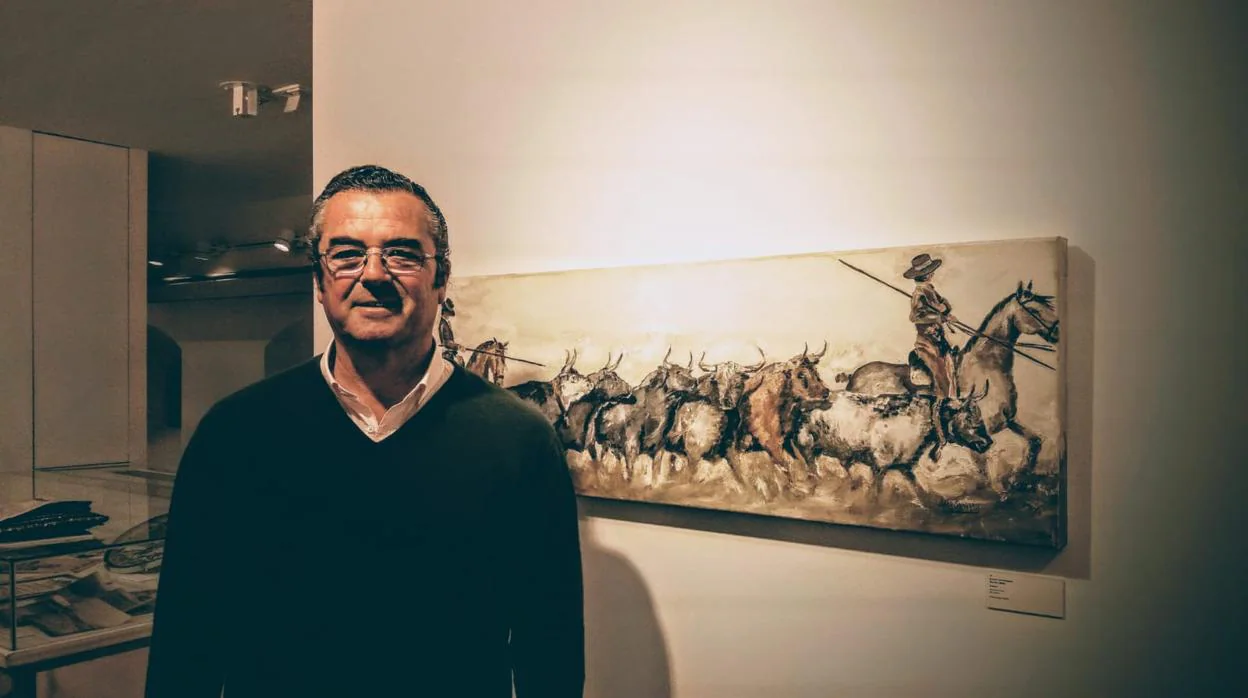 El ganadero y pintor Joaquín Lora junto a una de sus obras -