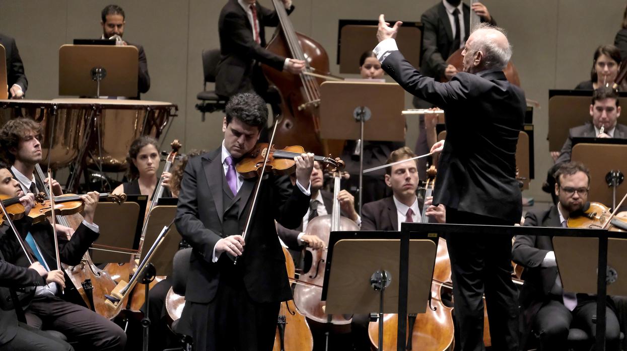 Daniel Barenboim dirigiendo a la orquesta y a su hijo Michael, solista de violín, en el Maestranza