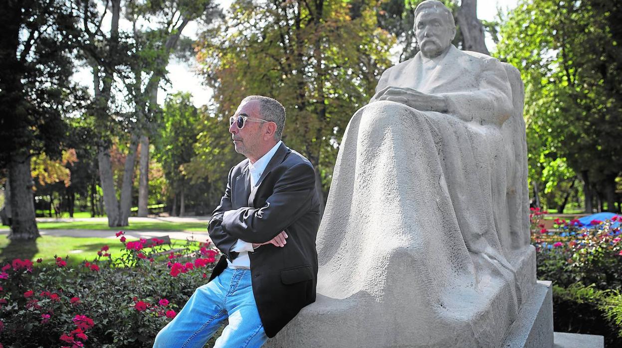 José Luis Garci posando junto a la estatua de Benito Pérez Galdos del parque de El Retiro