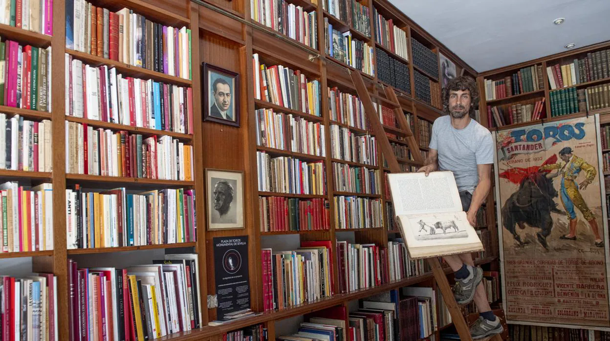 Carlos Ballesteros, en la madrileña librería Rodríguez, enseña una de las obras más valiosas desde una escalera