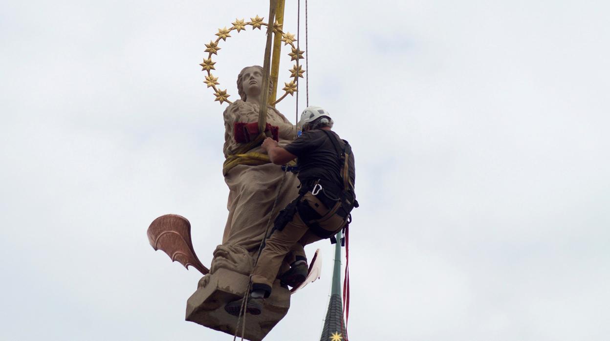 Un operario coloca la estatua de la Inmaculada en la Plaza Vieja de Praga