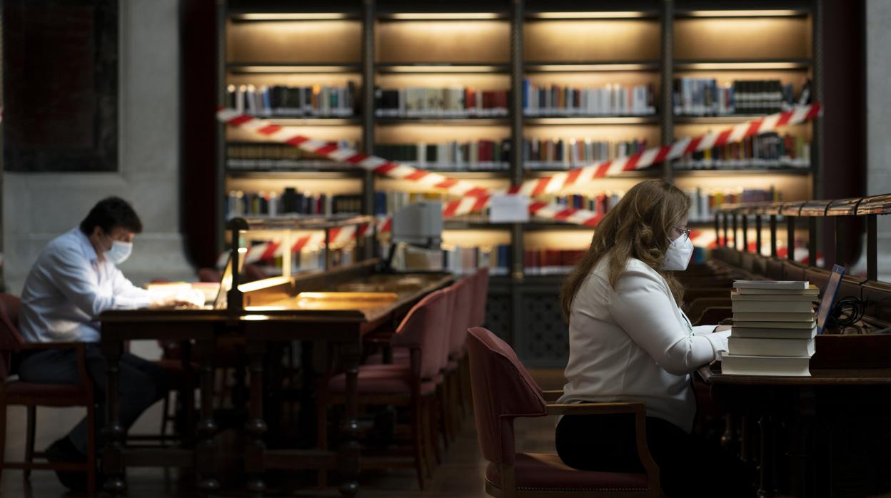 Dos investigadores trabajan en el Salón General de la Biblioteca Nacional de España tras su reapertura