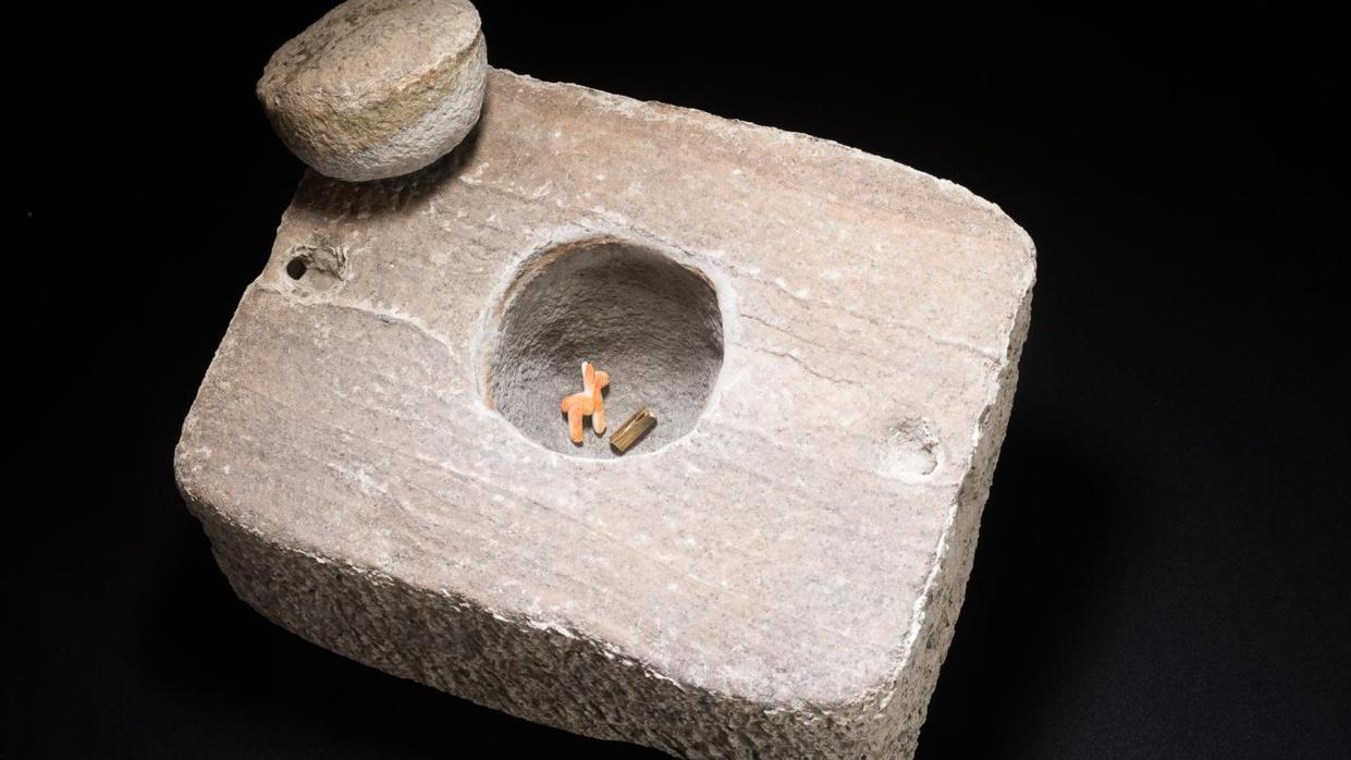 La caja de piedra tallada con los objetos en su interior
