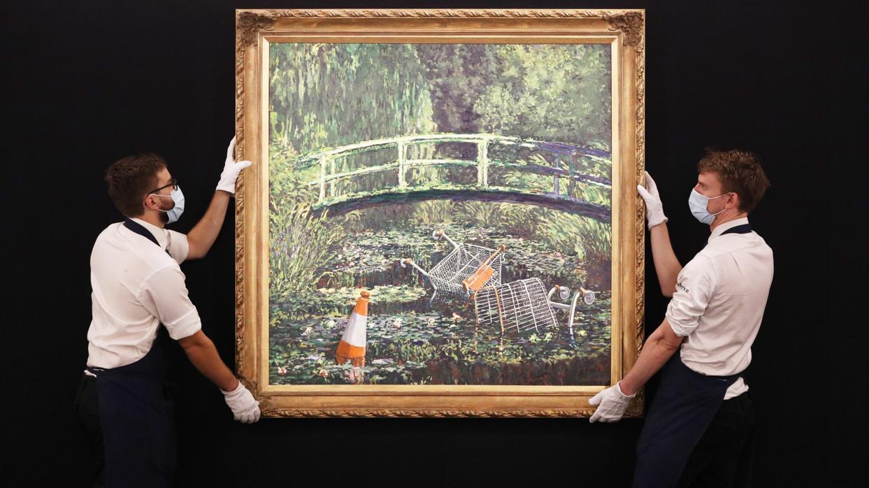 Dos trabajadores de Sotheby's portan «Muéstrame el Monet» de Banksy en la sede londinense de la casa de subastas