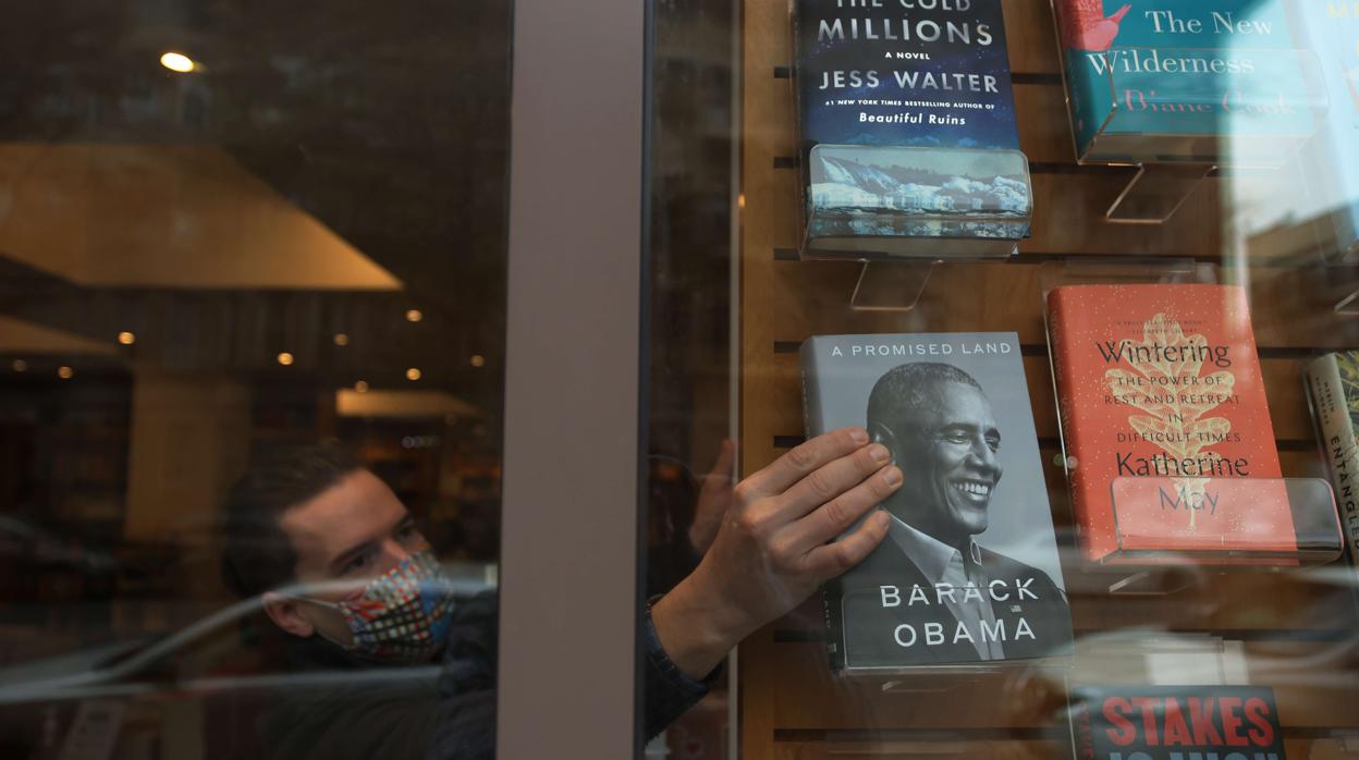 Niko Tsocanos coloca las memorias de Obama en el escaparate de la librería Greenlight, en Brooklyn (Nueva York)