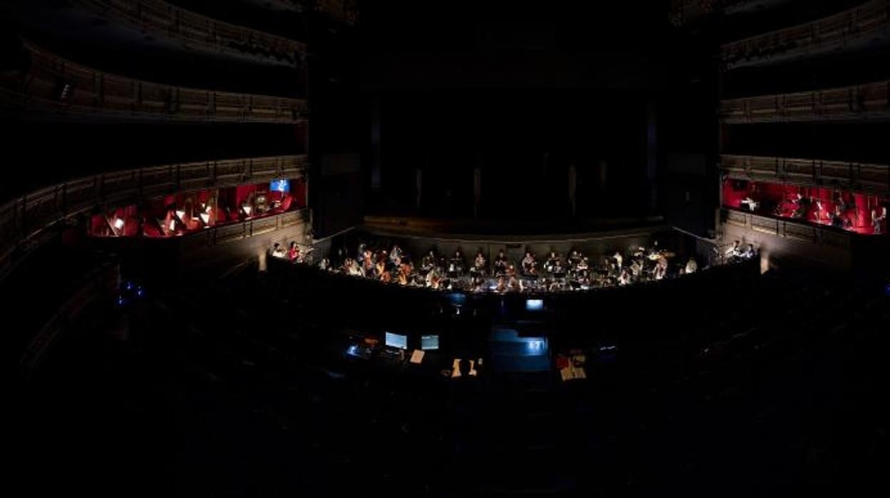 Aspecto del Teatro Real, con los músicos en el foso y fuera de él, durante un ensayo