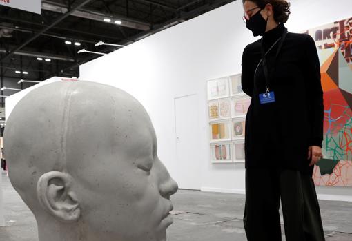 Una mujer contempla las obras del estand de 3Punts en la feria