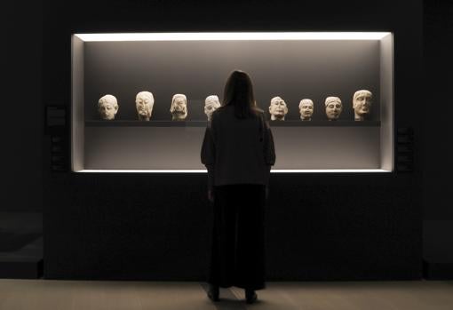 Una mujer admira piezas iberas expuestas en una vitrina