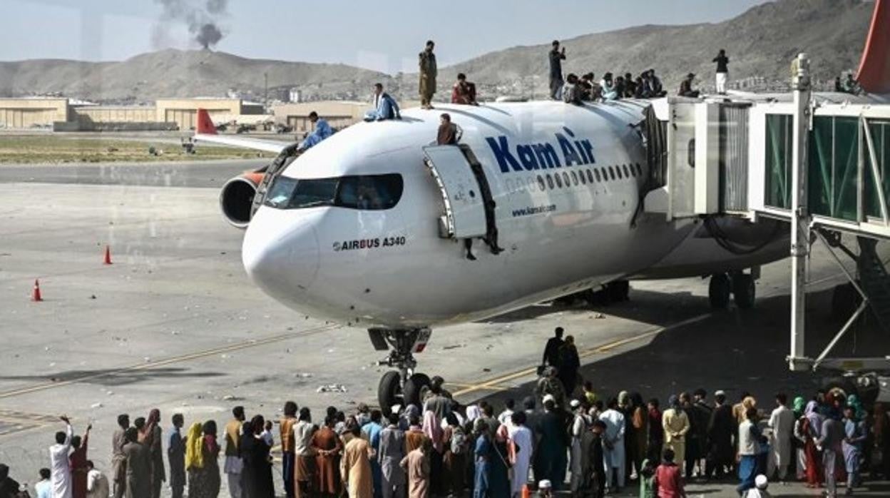 Ciudadanos afganos se suben a un avión mientras esperan en el aeropuerto de Kabul. (Foto de Wakil Kohsar / AFP)
