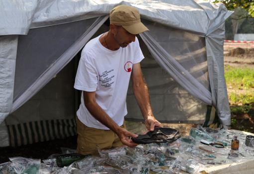 Un hombre muestra restos encontrados en el sitio de fosas comunes descubiertas en Odesa el 30 de agosto de 2021.