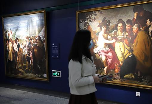 Una mujer frente a algunas réplicas de cuadros de Velázquez que se pueden ver en el Prado
